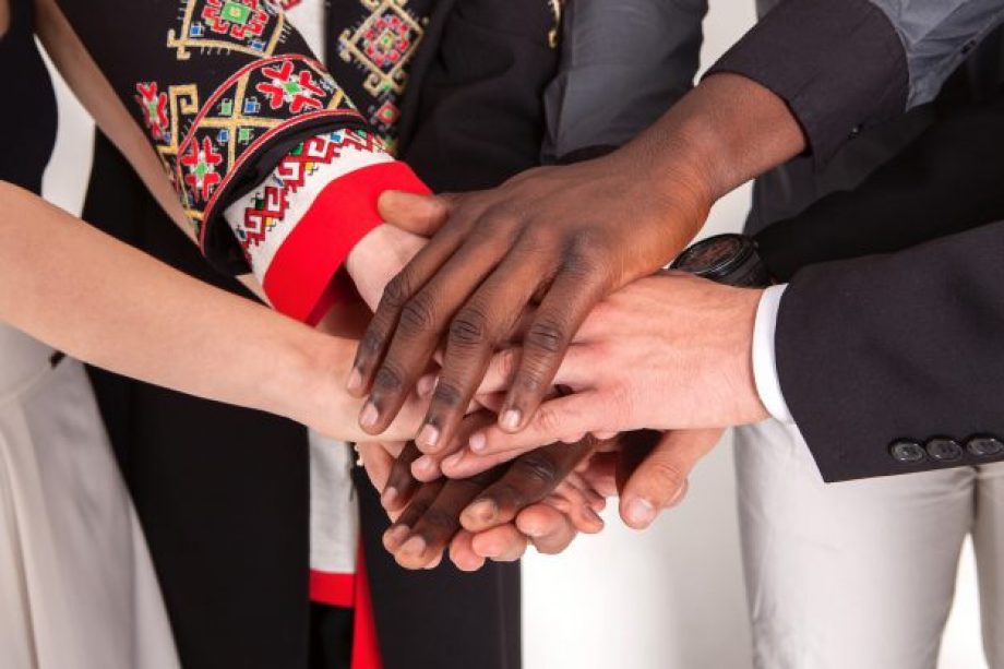 People of different nationalities and religions hold hands. The concept of friendship among peoples. Business concept of team building and partnerships.